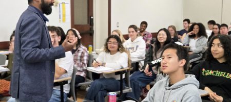 Professor Vetri Nathan, standing, with students seated and listening to his lecture.