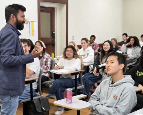 Professor Vetri Nathan, standing, with students seated and listening to his lecture.
