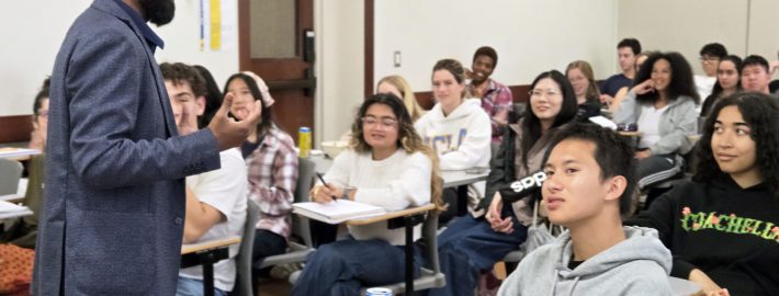 Professor Vetri Nathan, standing, with students seated and listening to his lecture.